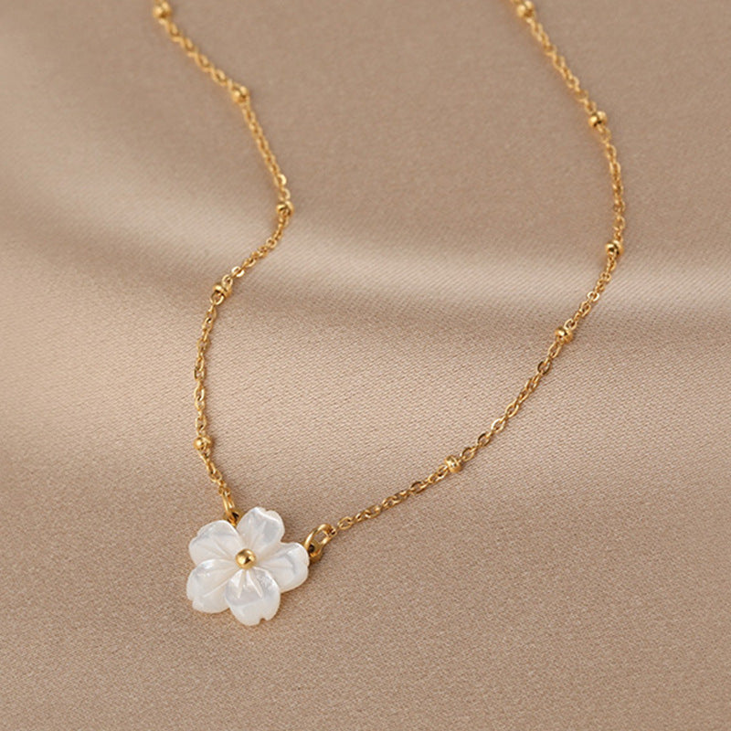 Elegant close-up of Golden Blossom Necklace displayed on a velvet stand