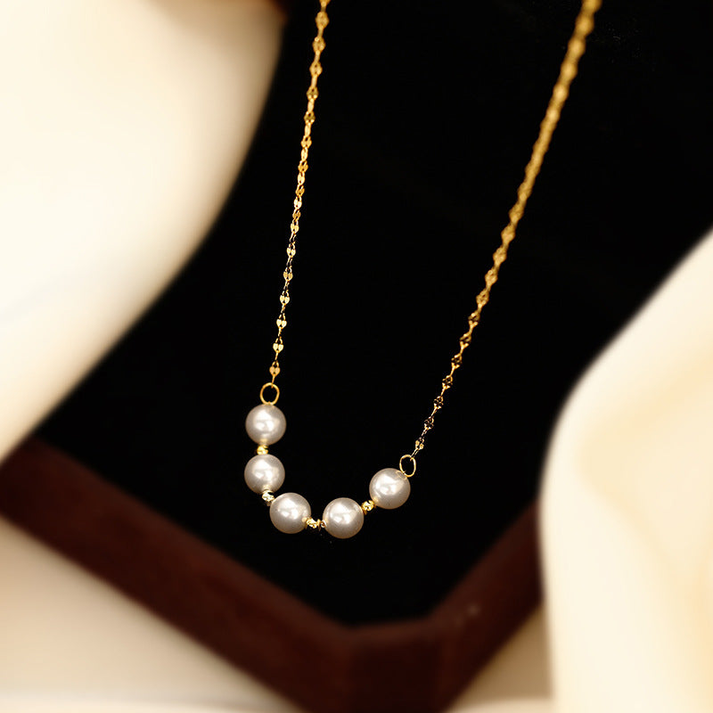 Elegant close-up of Golden-Pearl Grace Necklace displayed on a velvet stand