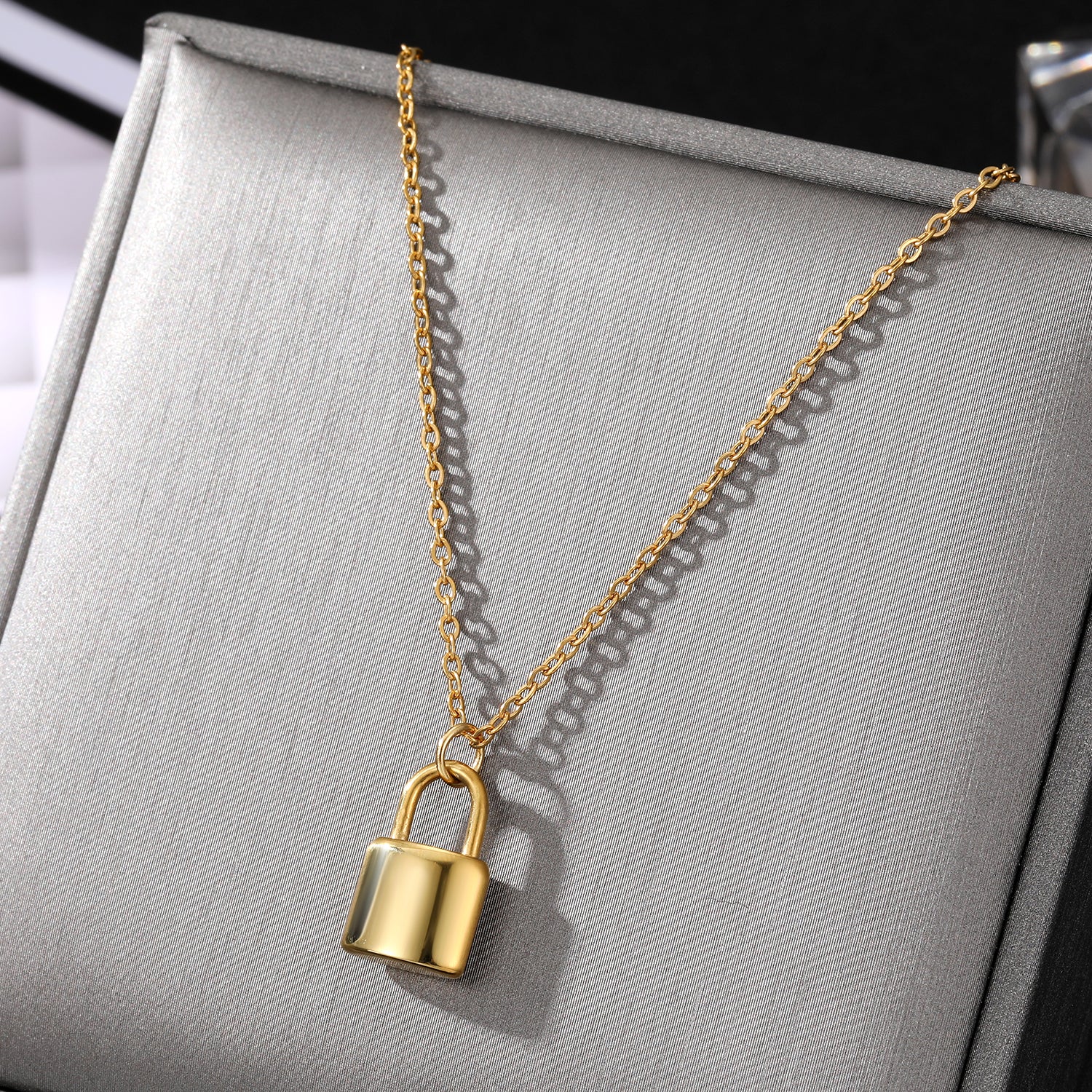 Elegant close-up of Golden Lockette Necklace displayed on a velvet stand