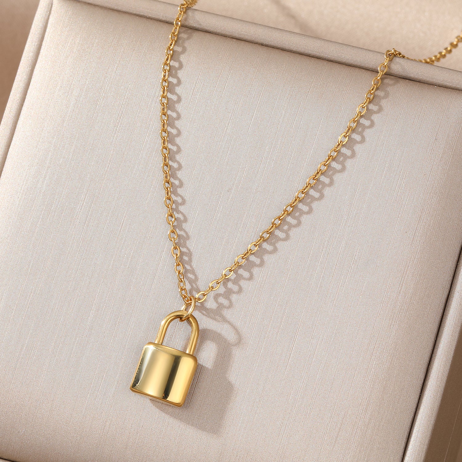 Elegant close-up of Golden Lockette Necklace displayed on a velvet stand