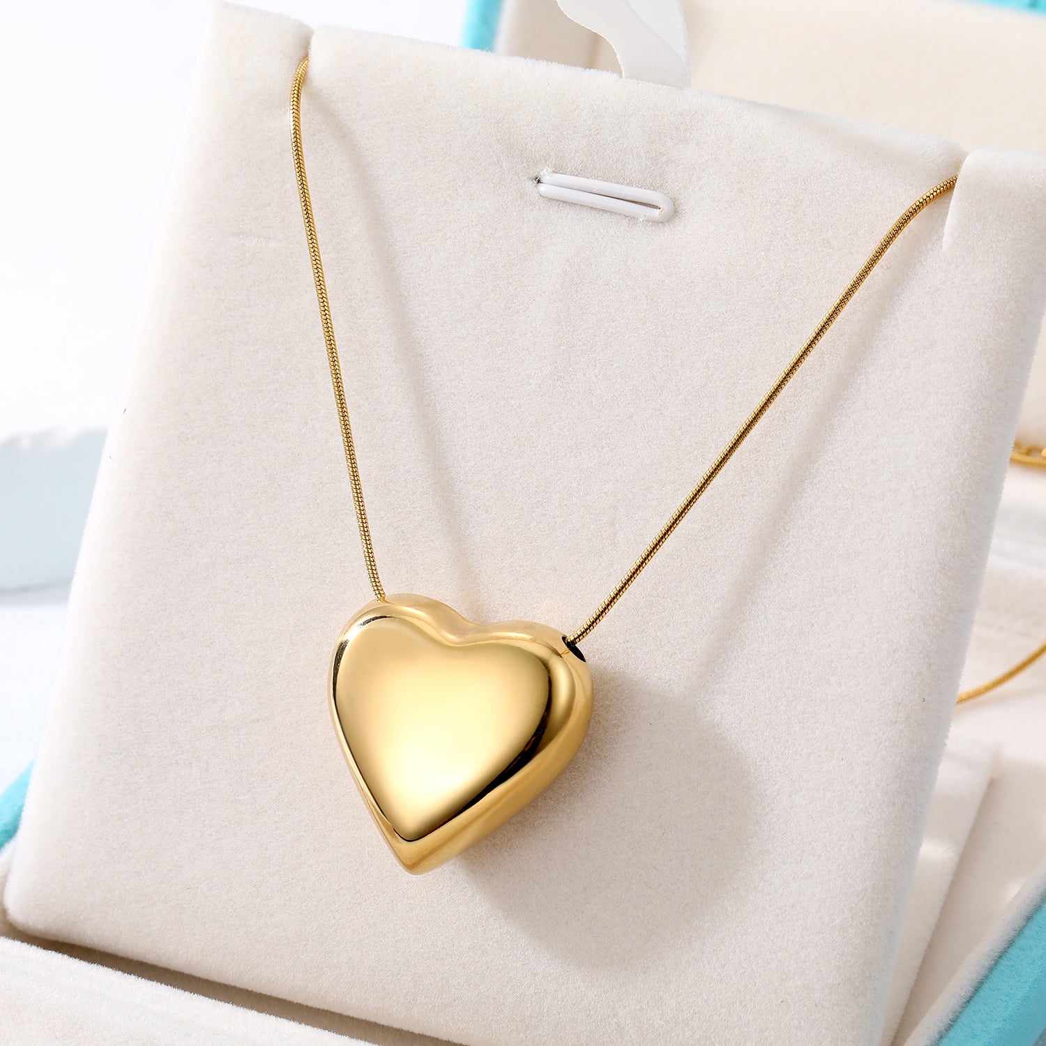 Elegant close-up of Golden Heart Necklace displayed on a velvet stand