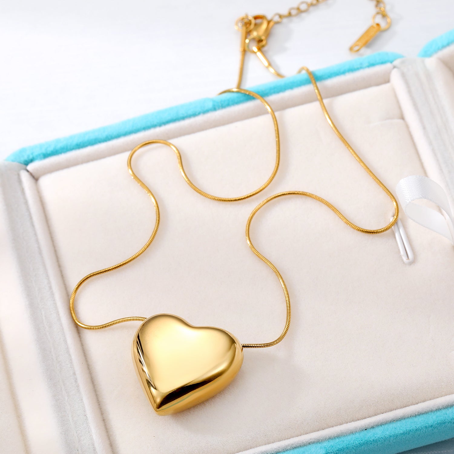 Elegant close-up of Golden Heart Necklace displayed on a velvet stand