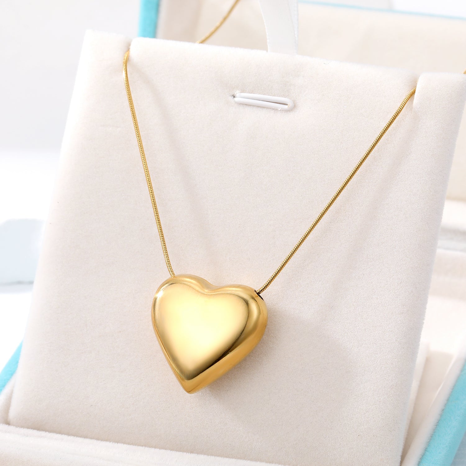 Elegant close-up of Golden Heart Necklace displayed on a velvet stand