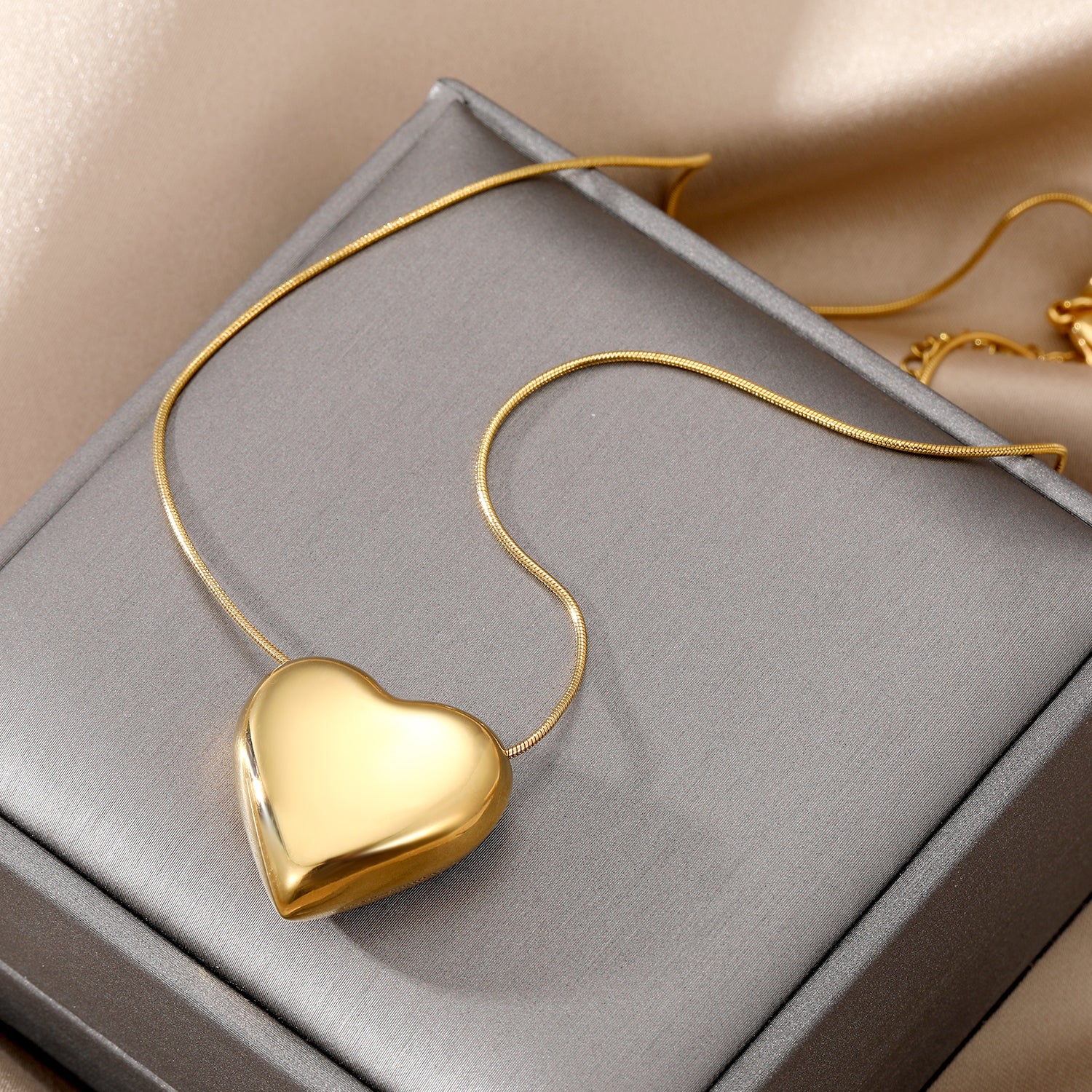 Elegant close-up of Golden Heart Necklace displayed on a velvet stand