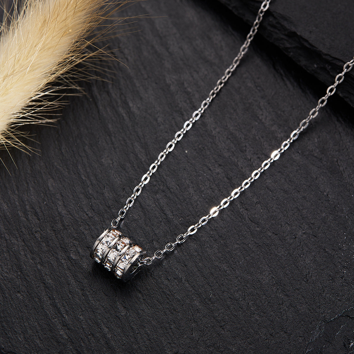 Elegant close-up of Silver Trinity Spark Necklace displayed on a velvet stand