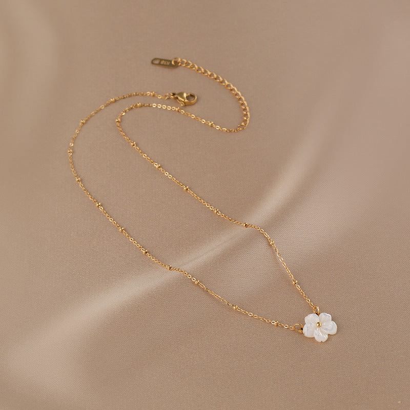 Elegant close-up of Golden Blossom Necklace displayed on a velvet stand