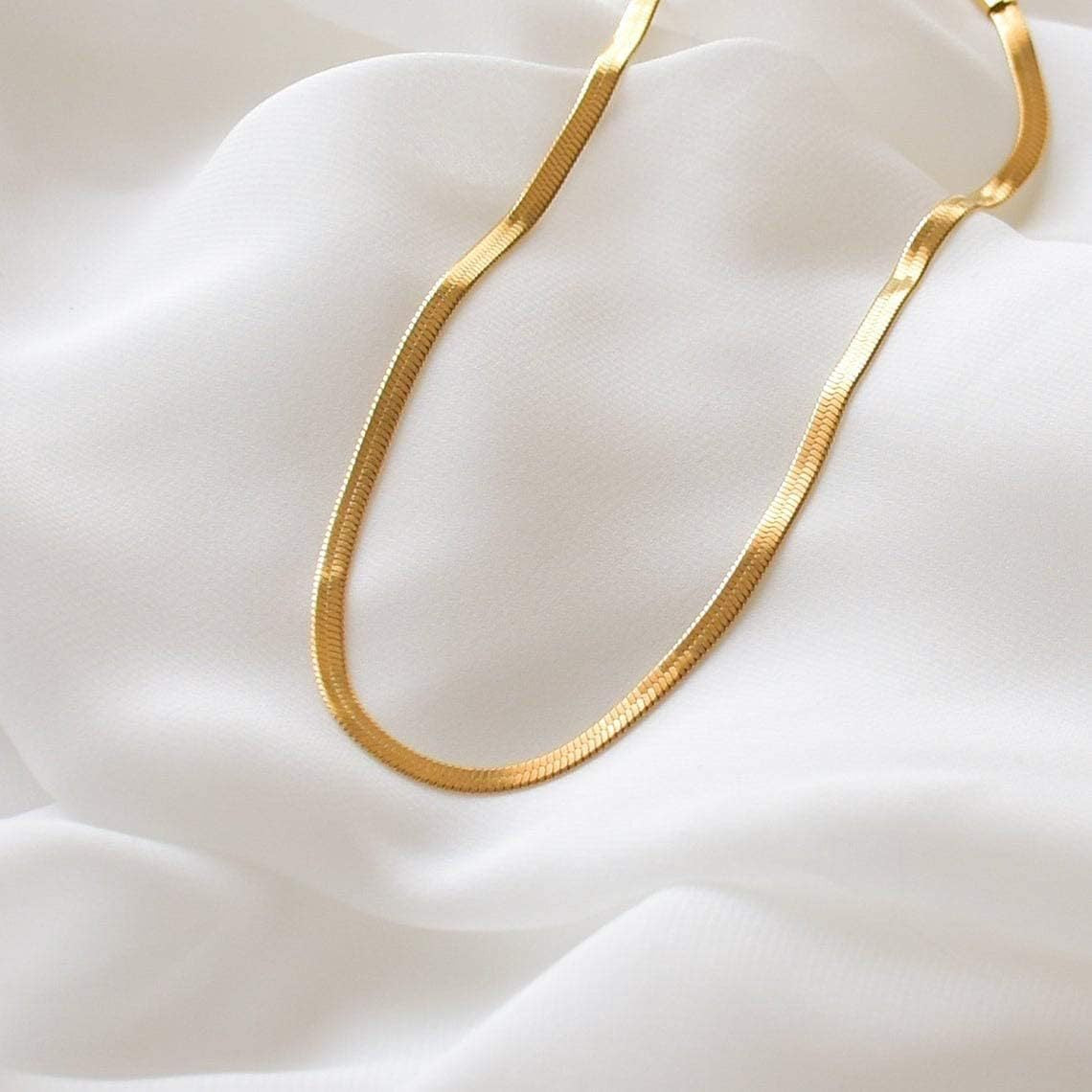 Elegant close-up of Gold Lume Chain displayed on a velvet stand