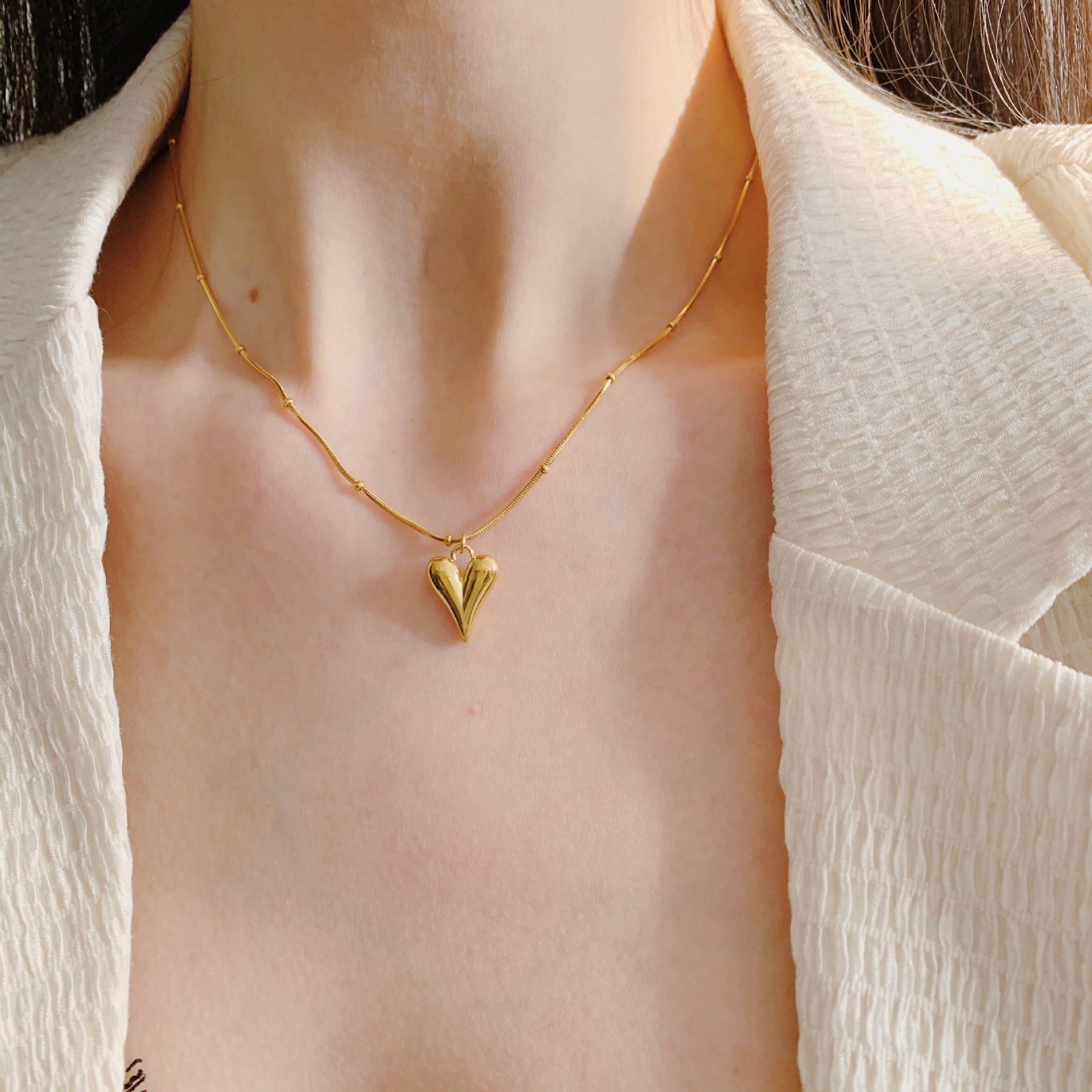 Elegant close-up of Lover’s Curve Necklace displayed on a velvet stand