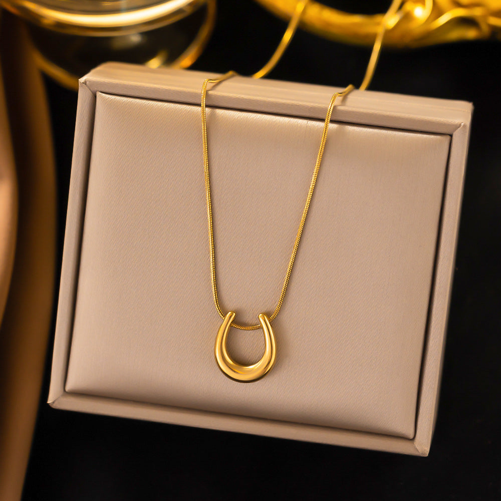 Elegant close-up of Golden Arc Necklace displayed on a velvet stand