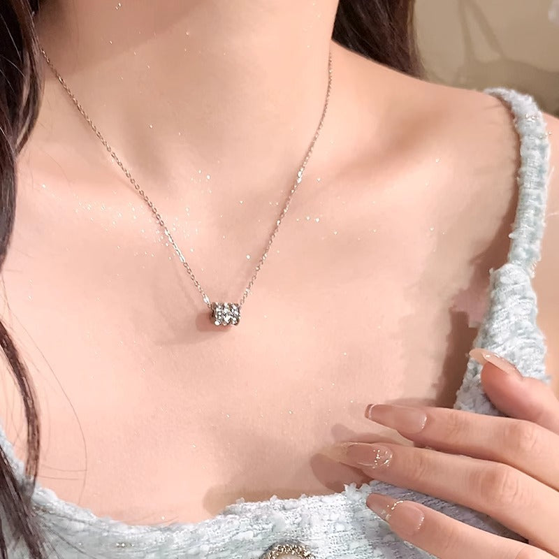 Elegant close-up of Silver Trinity Spark Necklace displayed on a velvet stand