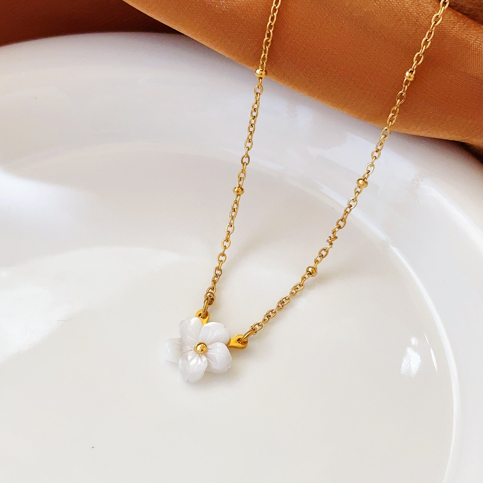 Elegant close-up of Golden Blossom Necklace displayed on a velvet stand