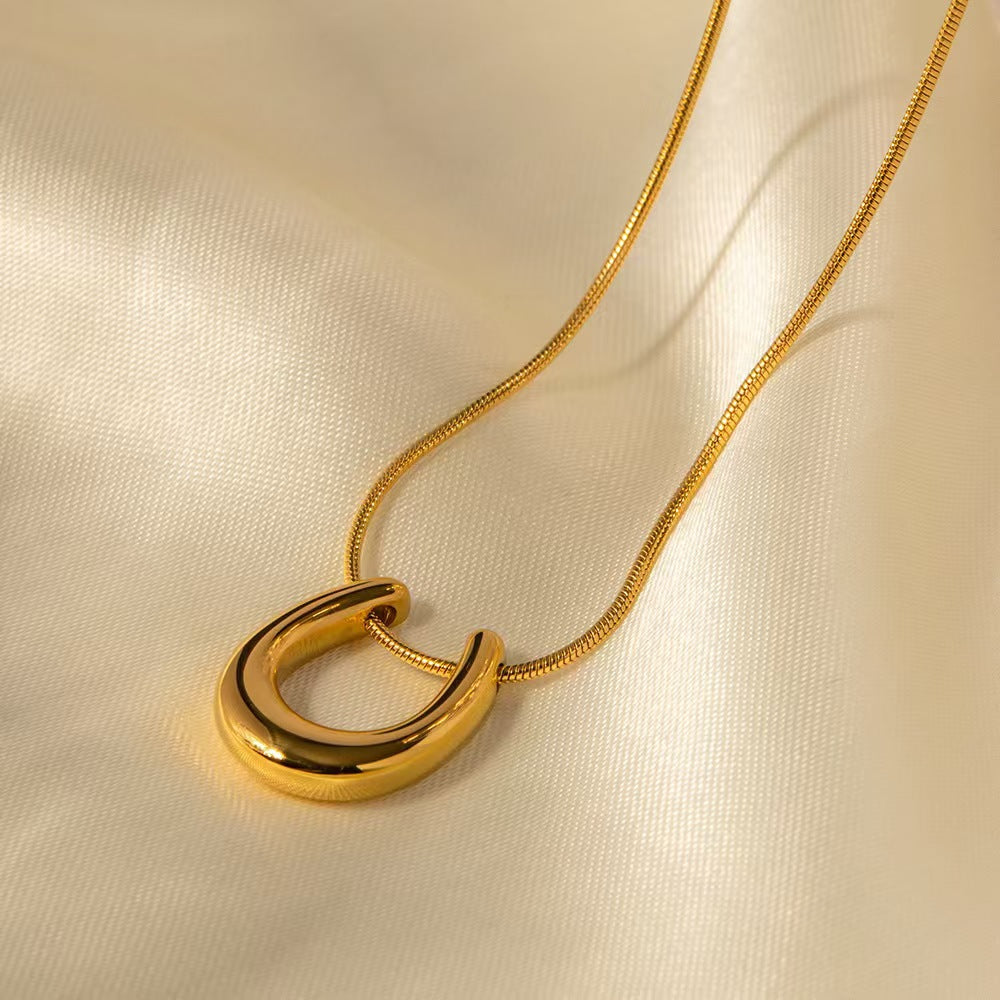 Elegant close-up of Golden Arc Necklace displayed on a velvet stand