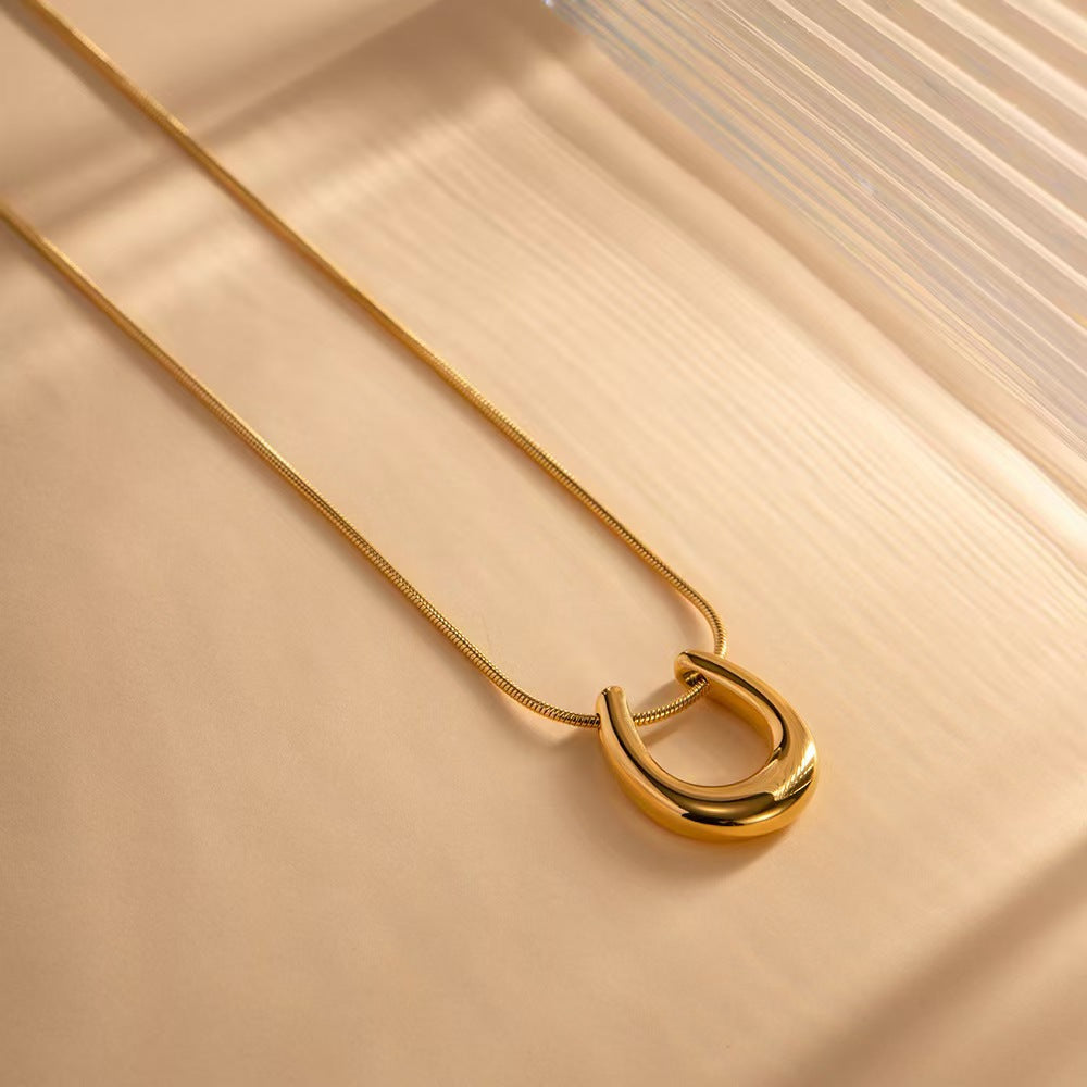 Elegant close-up of Golden Arc Necklace displayed on a velvet stand