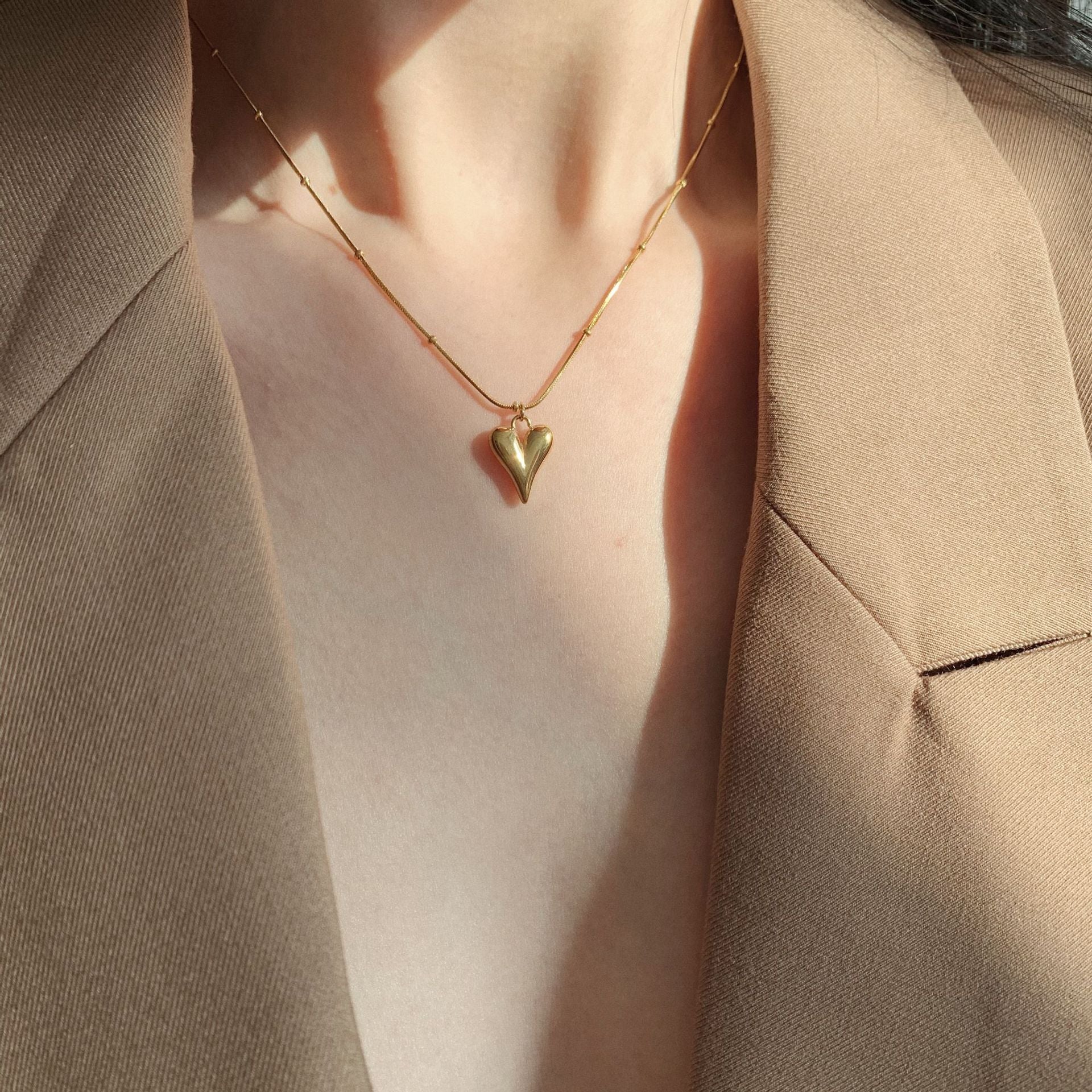 Elegant close-up of Loverâ€™s Curve Necklace displayed on a velvet stand