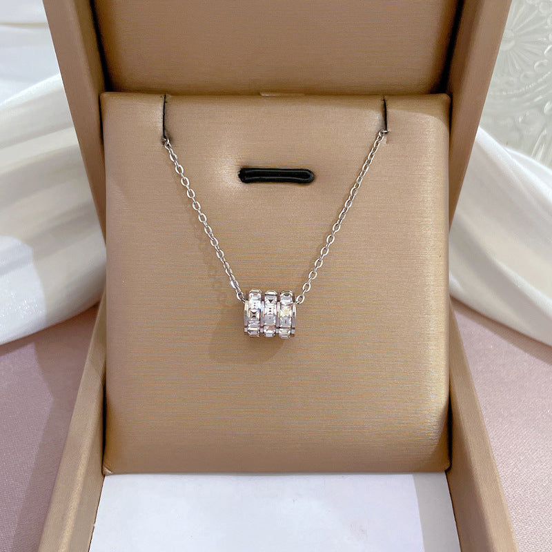 Elegant close-up of Silver Trinity Spark Necklace displayed on a velvet stand