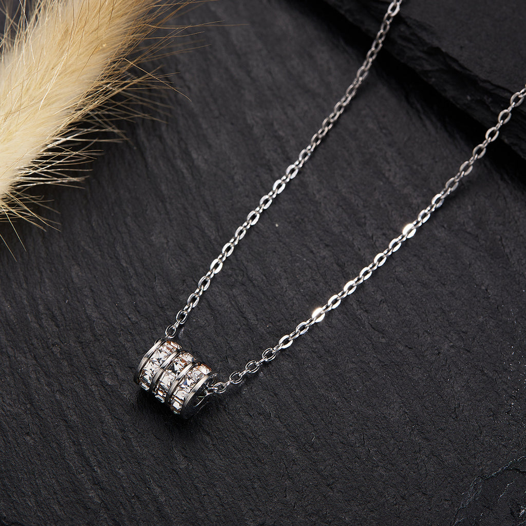 Elegant close-up of Silver Trinity Spark Necklace displayed on a velvet stand