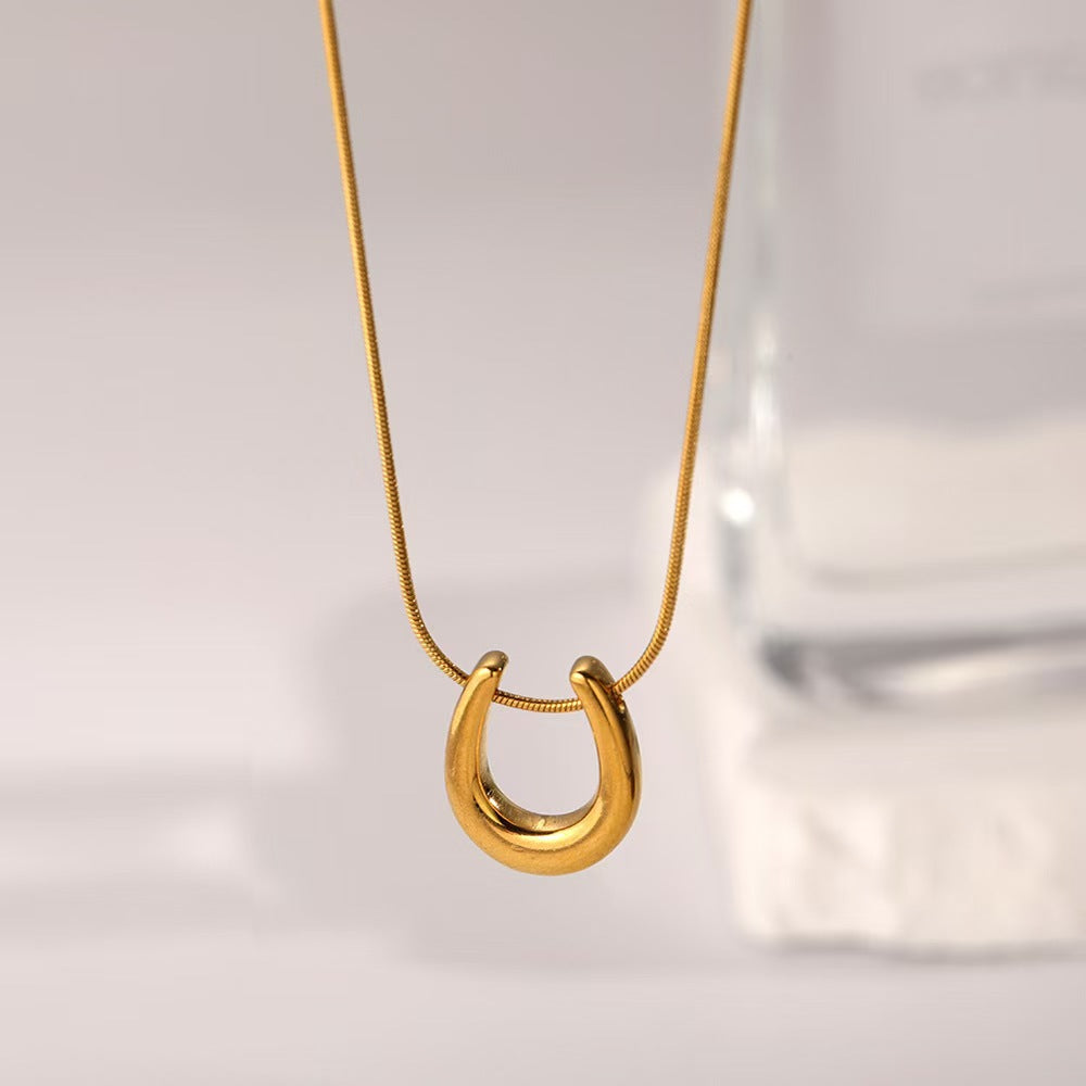 Elegant close-up of Golden Arc Necklace displayed on a velvet stand