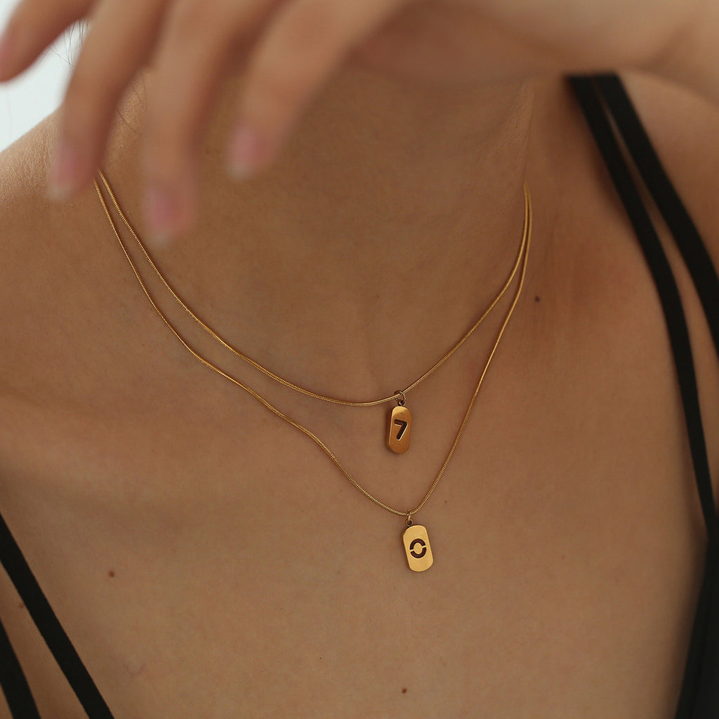 Elegant close-up of Golden Six Necklace displayed on a velvet stand