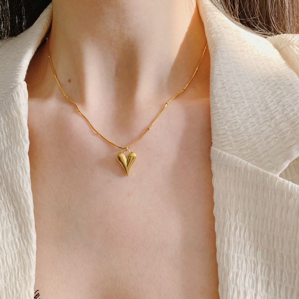 Elegant close-up of Loverâ€™s Curve Necklace displayed on a velvet stand