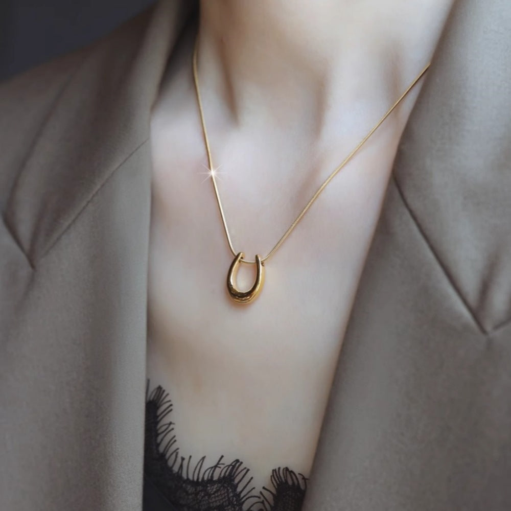 Elegant close-up of Golden Arc Necklace displayed on a velvet stand