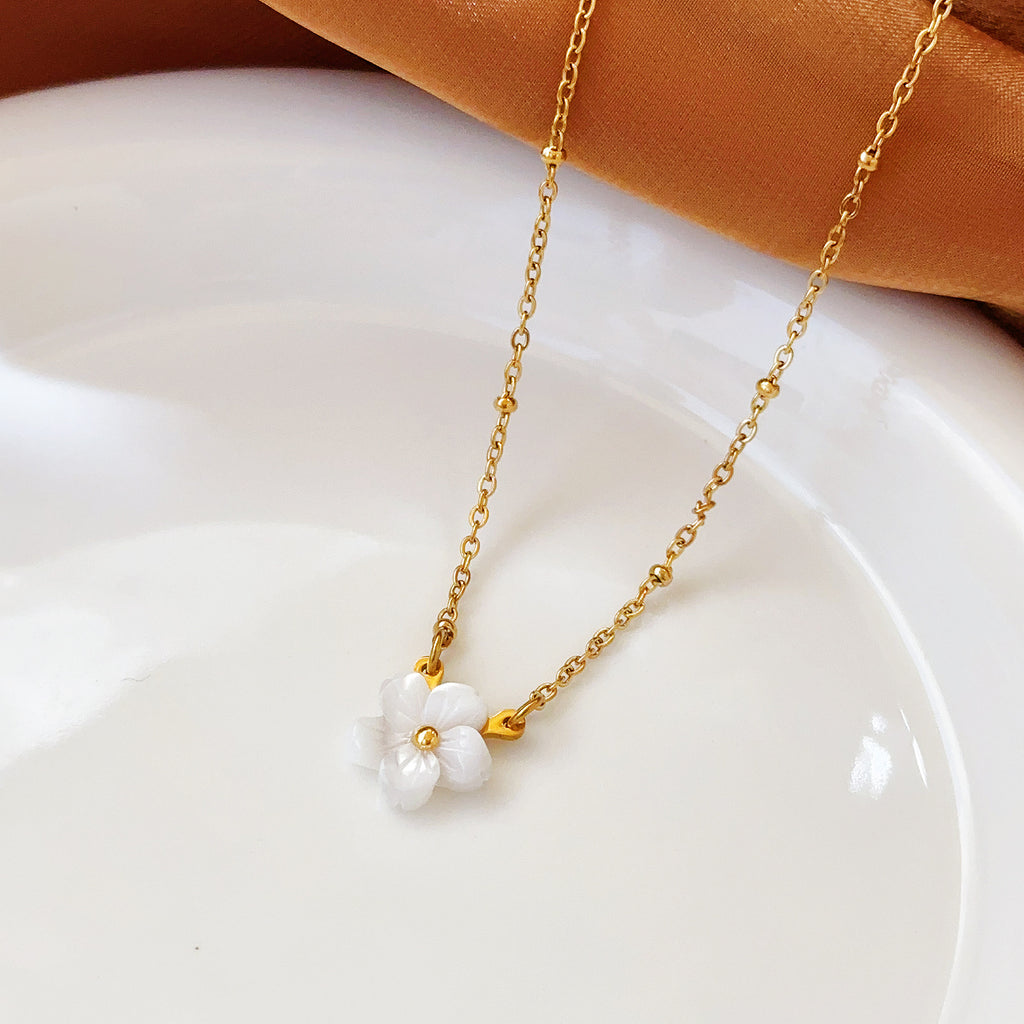 Elegant close-up of Golden Blossom Necklace displayed on a velvet stand