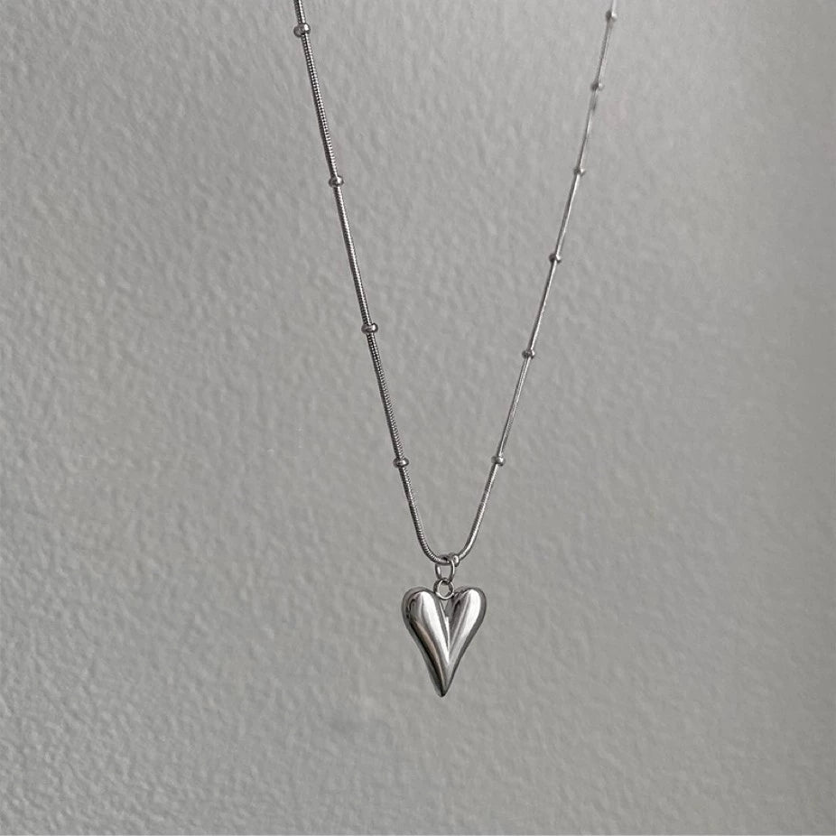 Elegant close-up of Lover's Silver Necklace displayed on a velvet stand